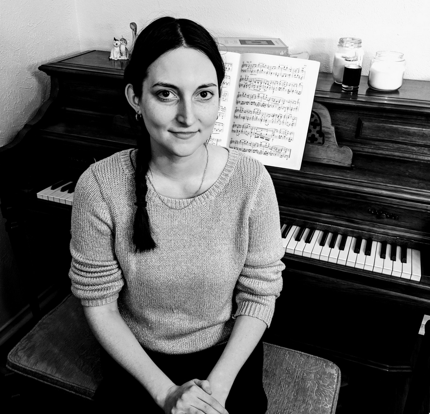 Picture of Sarah Hussein seated in front of an upright piano